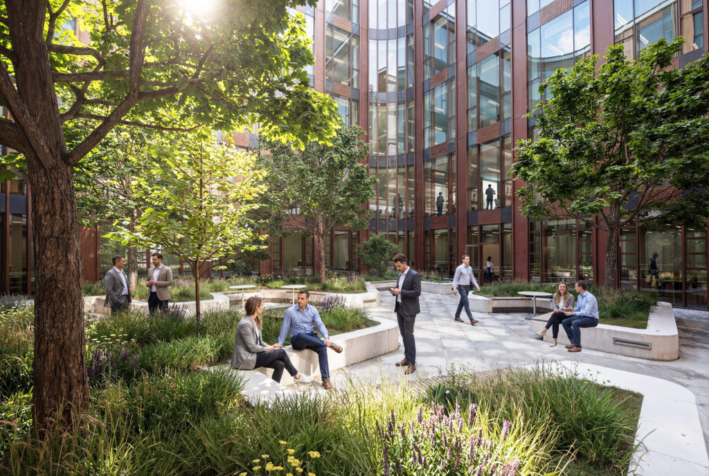 People talking and sitting on benches in a modern office courtyard with trees and sunshine.
